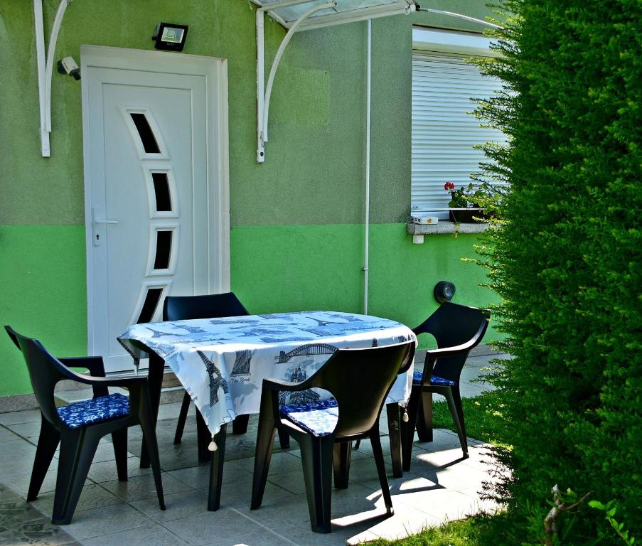 a table and chairs in a patio with a door at Tiszafa Vendégház Nagykanizsa in Nagykanizsa