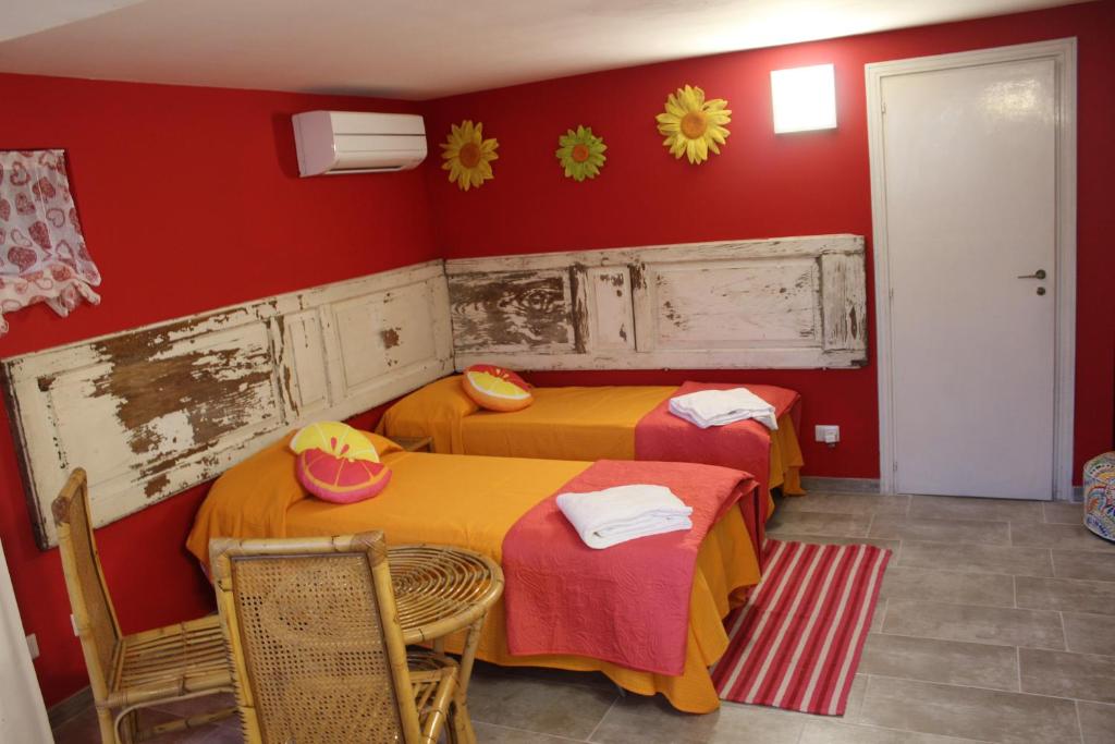 two beds in a room with red walls at Ellysblue Guesthouse in Pizzo
