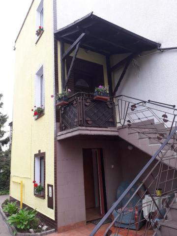 un edificio con balcón y escalera. en Pensjonat AIDA, en Ciechocinek
