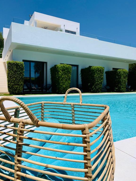 a wooden bench sitting next to a swimming pool at Casa Bodhi Boutique Hotel & Spa in Marbella