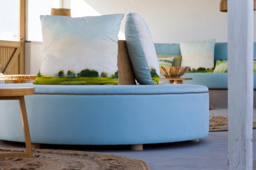 a blue couch with pillows on it in a living room at Hortas do Rio - Casa de Campo in Carrapateira