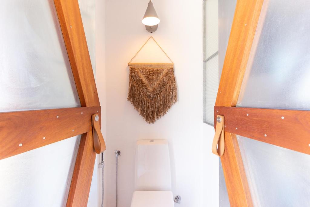 a bathroom with two wooden doors and a toilet at Hortas do Rio - Casa de Campo in Carrapateira