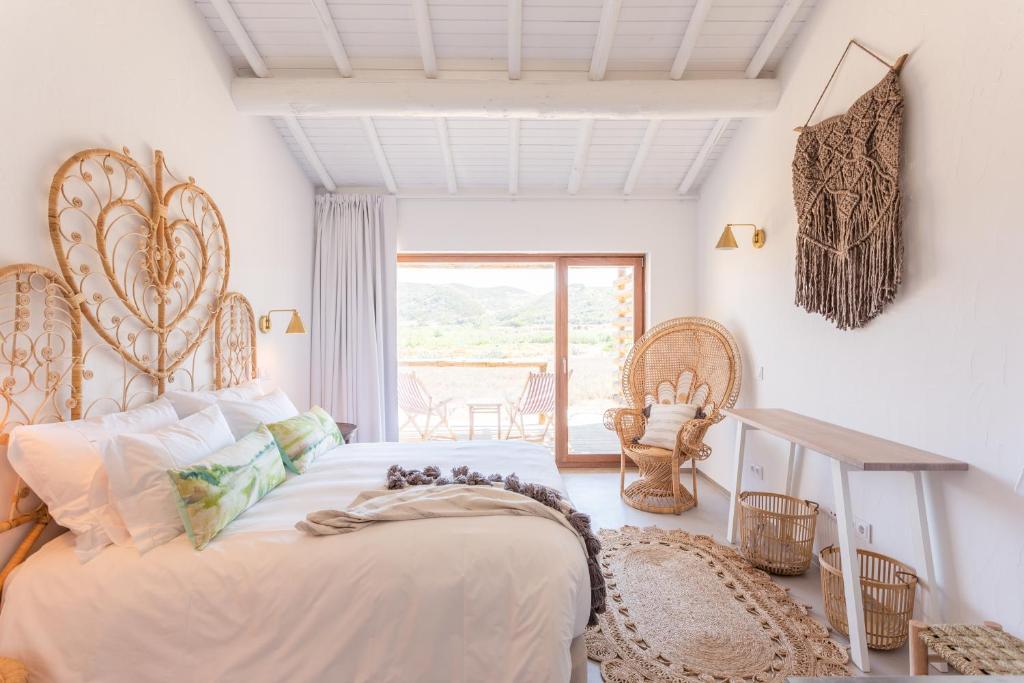 ein Schlafzimmer mit einem großen Bett und einem Fenster in der Unterkunft Hortas do Rio - Casa de Campo in Carrapateira