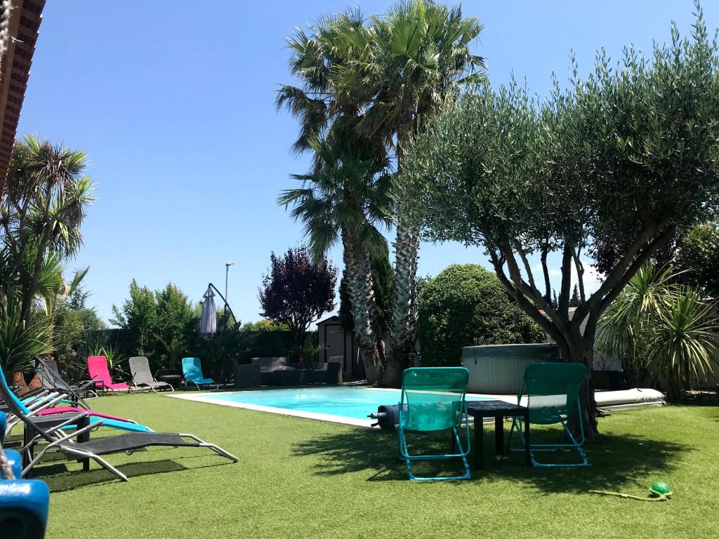 una piscina con sillas y una mesa junto a una piscina en Gîte de Larmonys, en Gigean