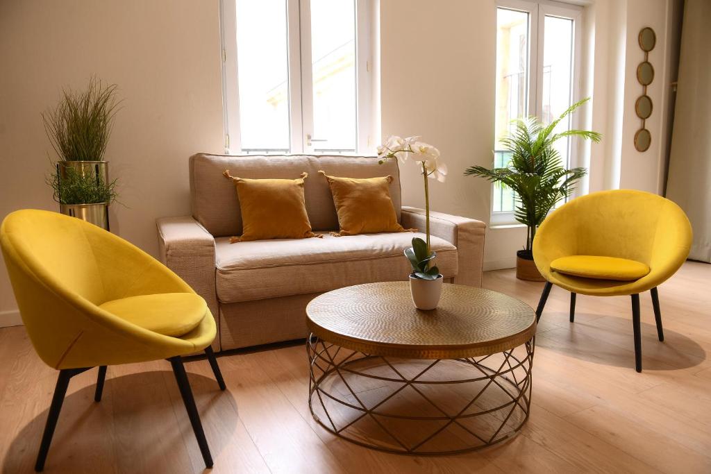 ein Wohnzimmer mit gelben Stühlen und einem Sofa in der Unterkunft THEATRE 9 in Dijon