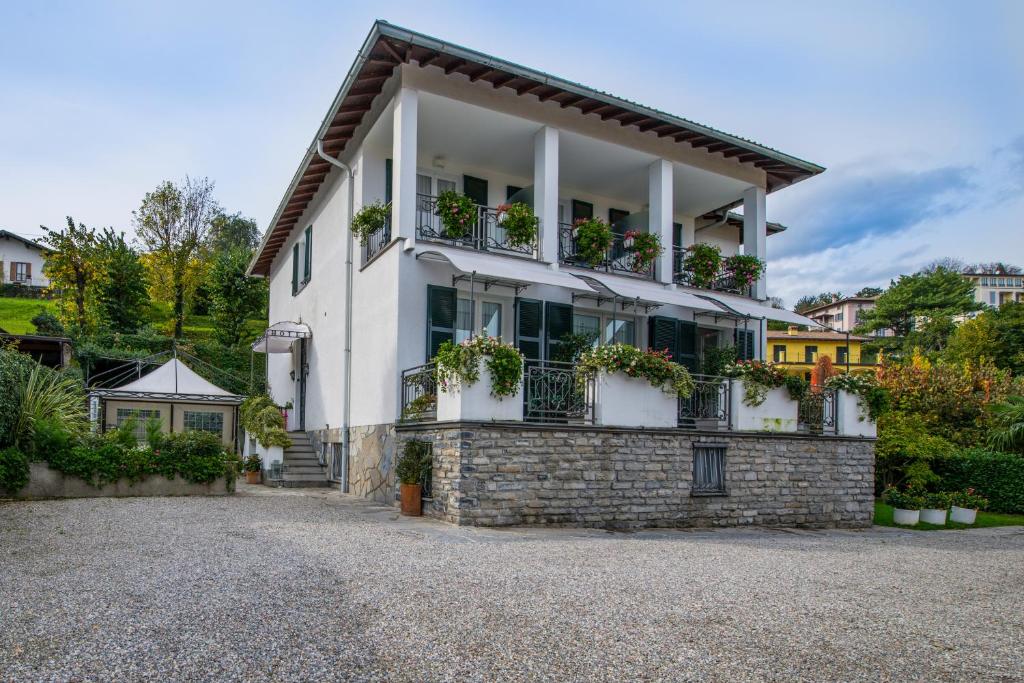 una casa bianca con piante in vaso sul balcone di Miralago B&B and Apartments a Bellagio