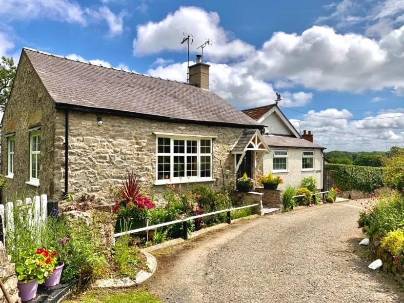 una antigua casa de piedra con una entrada de grava en Nesscliffe en Llangollen