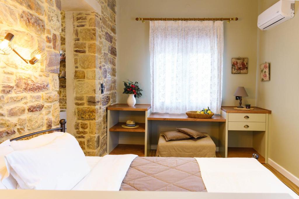 - une chambre avec un lit et un mur en pierre dans l'établissement Voulamandis House, à Kambos