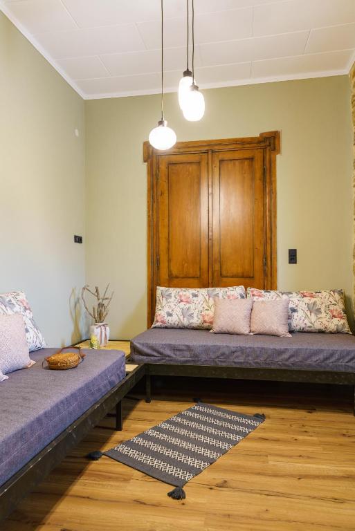 a living room with two beds and a rug at Voulamandis House in Kambos