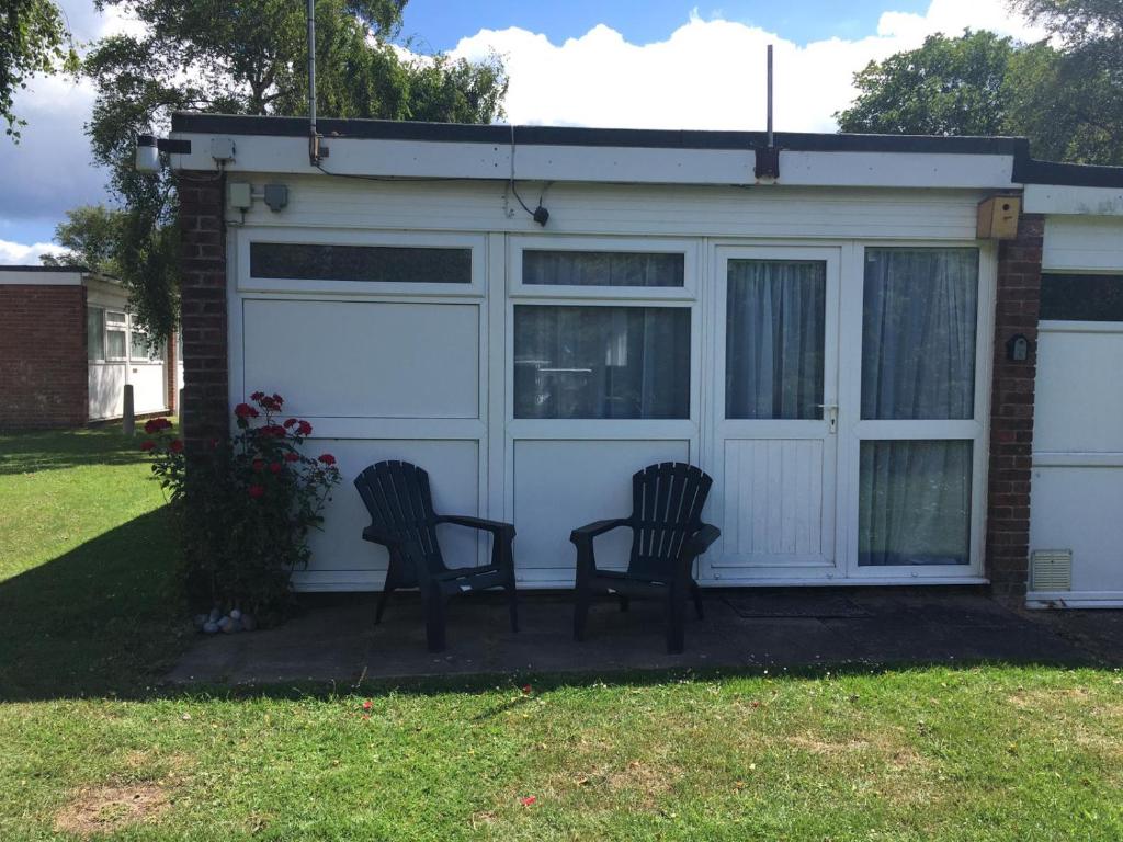 two chairs sitting in front of a garage at 185 Belle Aire, Beach Road, Hemsby, Norfolk, NR29 4HZ in Hemsby