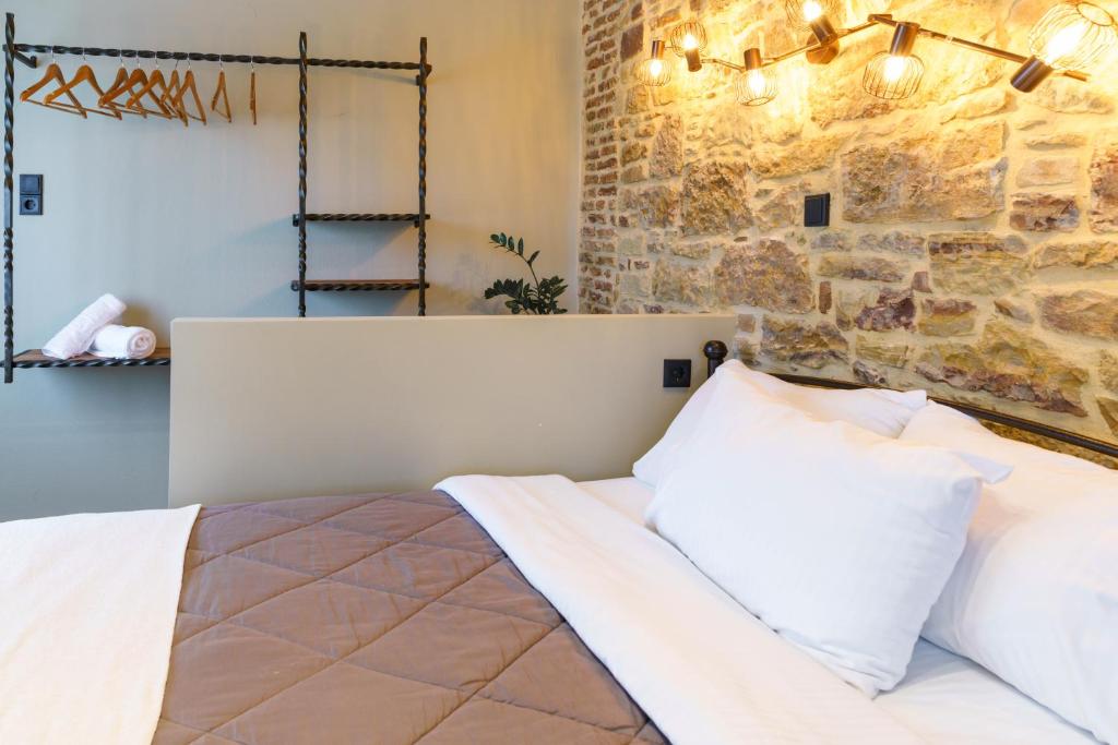 a bedroom with a bed and a stone wall at Voulamandis House in Kambos