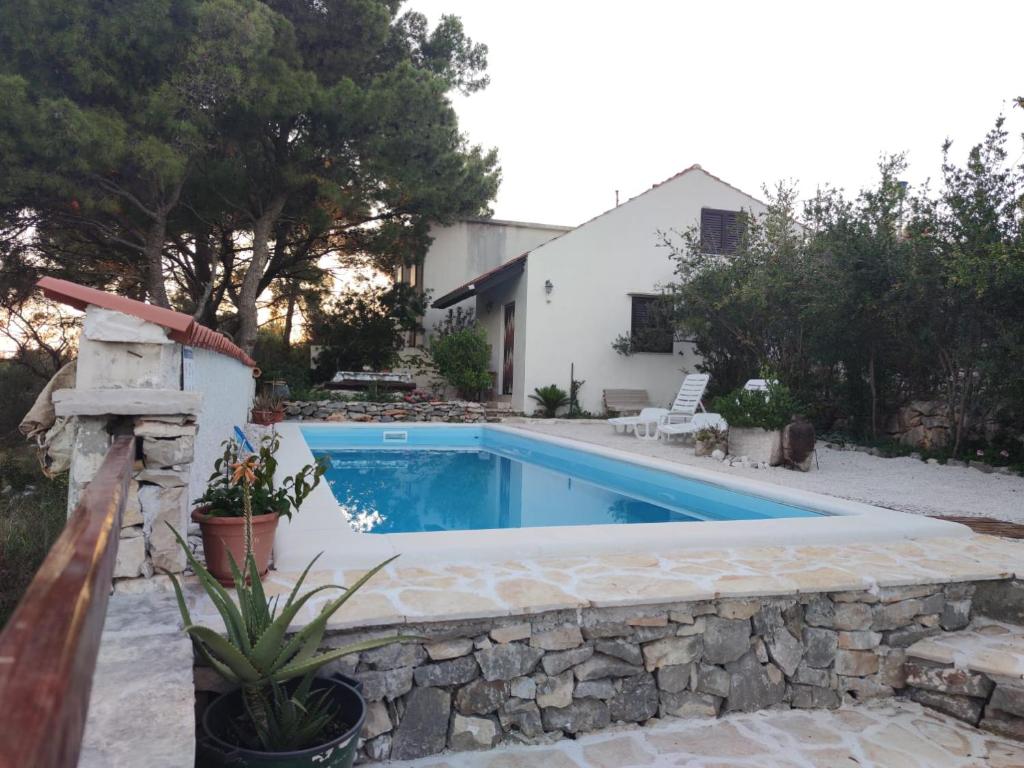 una piscina en un patio con una pared de piedra en Vacation house Milka, en Milna