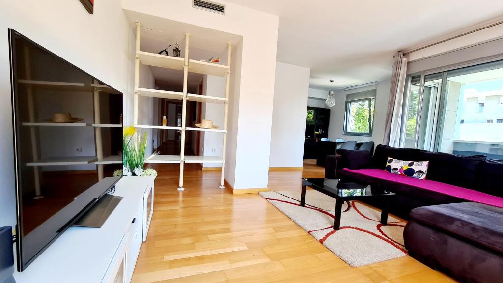 ein Wohnzimmer mit einem Sofa und einem TV in der Unterkunft Forum-CCIB-Relax Flats in Barcelona