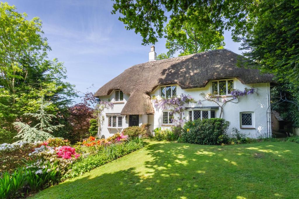 Cabaña con techo de paja y jardín frente a ella en Forest Drove Cottage · Idyllic New Forest 6 Bedroom Thatched Cottage en Ringwood