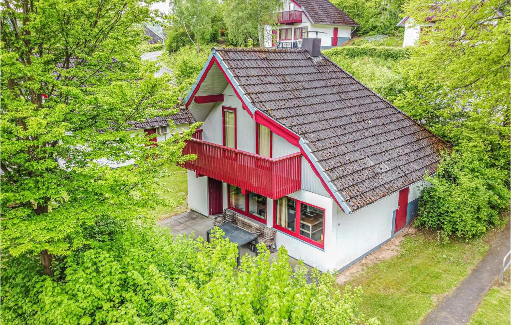 une maison rouge et blanche sur une colline plantée d'arbres dans l'établissement Ferienhaus 39 In Kirchheim, à Kirchheim
