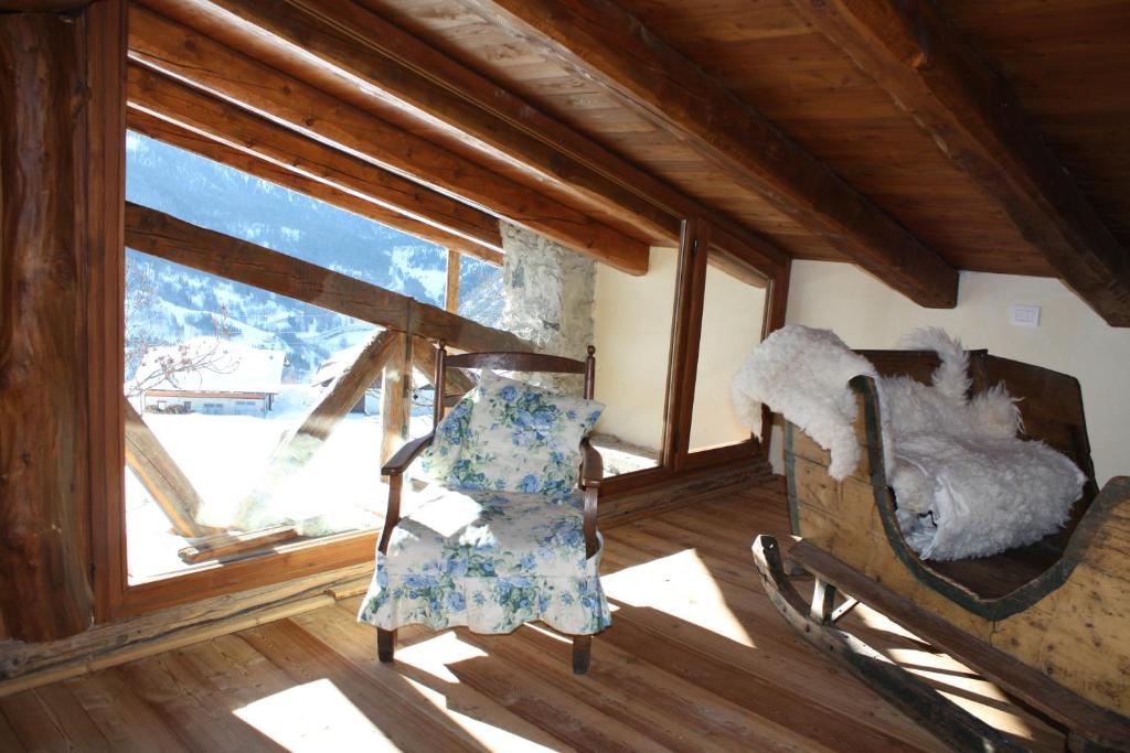 a living room with a chair and a window at Agriturismo Barba Gust in Cesana Torinese