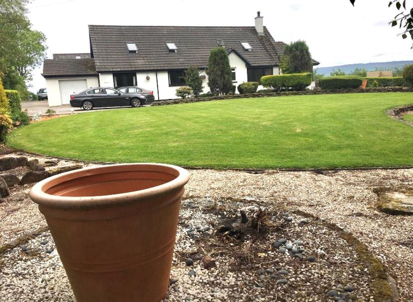 um grande pote sentado em frente a uma casa em Kilberry Guest House em Beauly