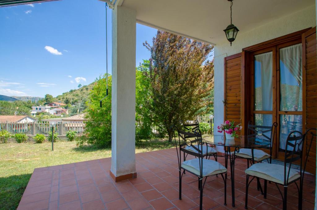 eine Terrasse mit Tisch und Stühlen auf einer Veranda in der Unterkunft Villa al mare a Santa Maria di Castellabate in Santa Maria di Castellabate
