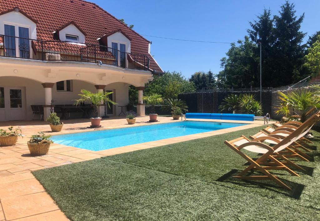 a swimming pool in the backyard of a house at Oázis Panzió in Gyenesdiás