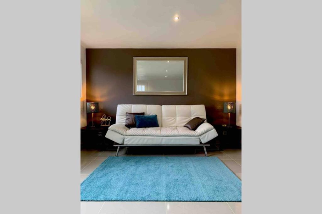 a living room with a white couch and a blue rug at Appartement 3km Disneyland Paris 4 à 6 personnes in Magny-le-Hongre