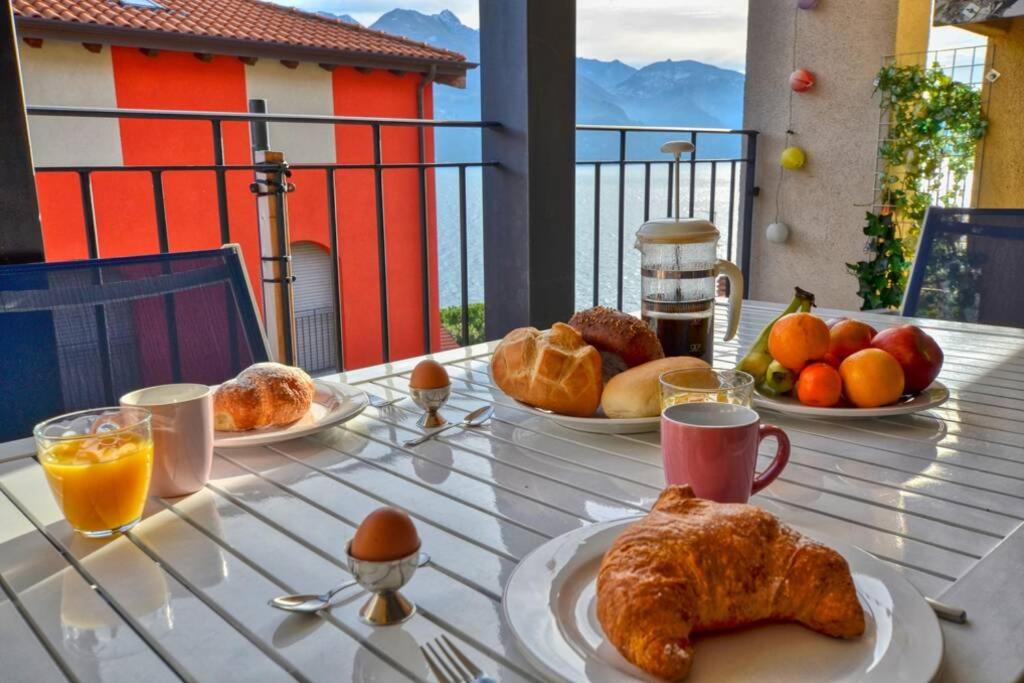einen Tisch mit Frühstücksteller darauf in der Unterkunft Wohnung mit Seeblick, Strandnähe und Tiefgaragen Stellplatz in Acquaseria