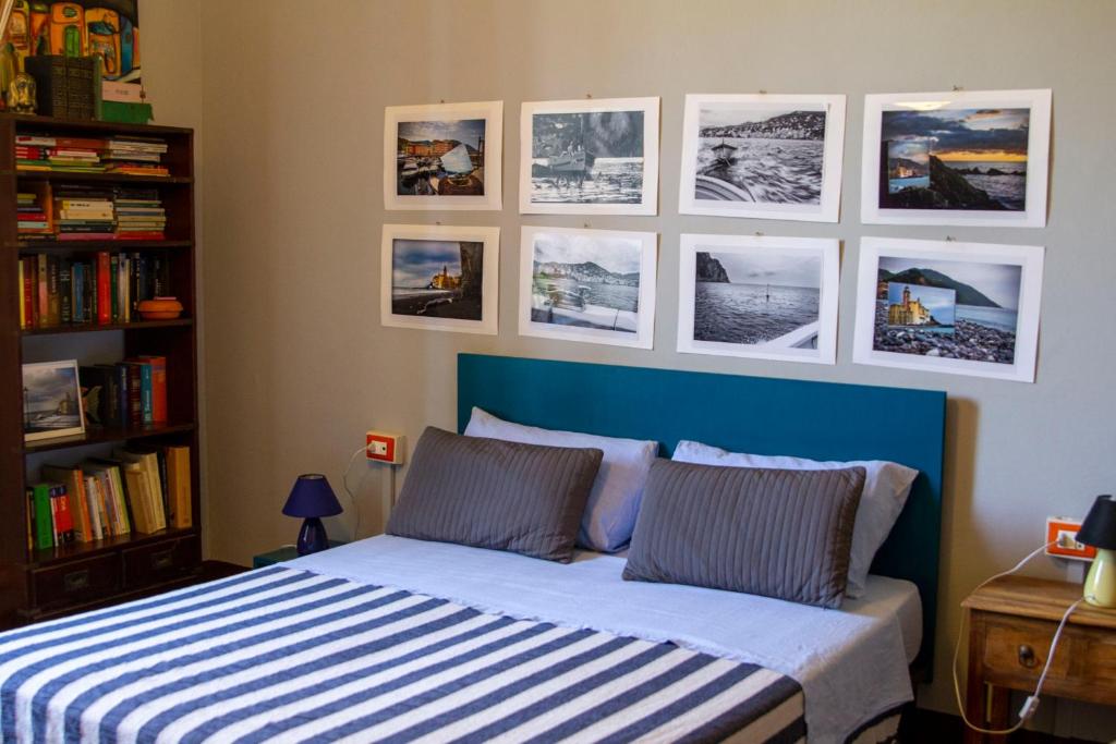 a bed in a bedroom with pictures on the wall at L'Andirivieni in Camogli