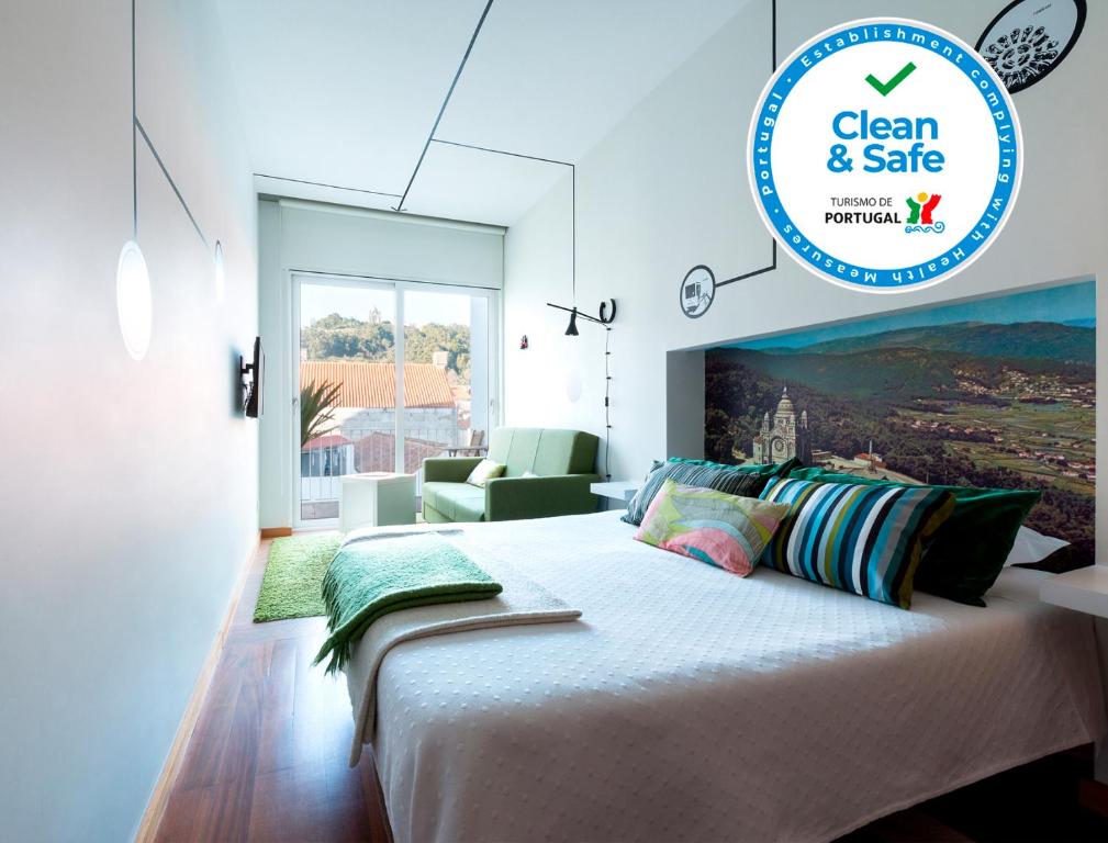 1 dormitorio blanco con 1 cama grande y 1 silla en Pensao O Laranjeira en Viana do Castelo