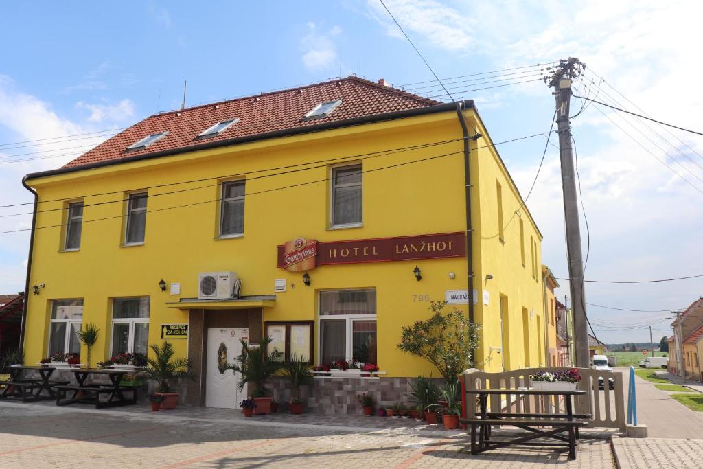 un edificio amarillo con un banco delante de él en Hotel u Nádraží Lanžhot, en Lanžhot