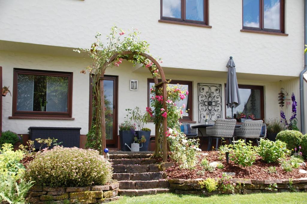 ein Haus mit einem Sonnenschirm und einer Terrasse in der Unterkunft Ferienwohnung Hoffmann in Osburg