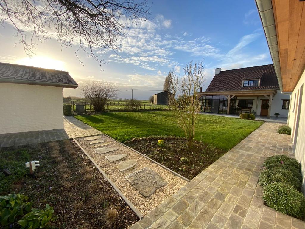 a house with a walkway next to a yard at Madelette B&B in Moorslede