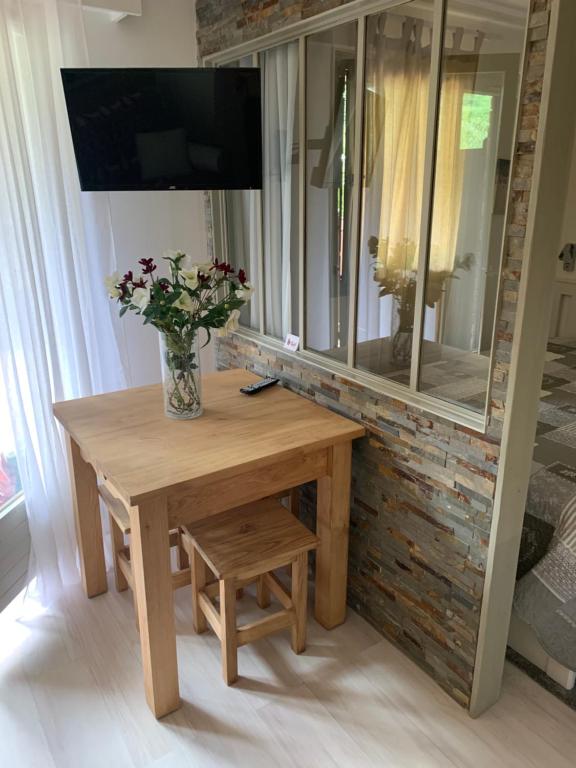 a wooden table with a vase of flowers on it at les Cimes d'Or Mont blanc in Les Contamines-Montjoie