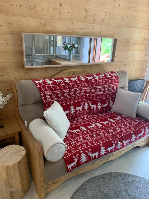 a couch with a red blanket on it in a room at les Cimes d'Or Mont blanc in Les Contamines-Montjoie