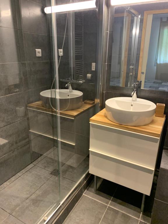 a bathroom with two sinks and a glass shower at les Cimes d'Or Mont blanc in Les Contamines-Montjoie