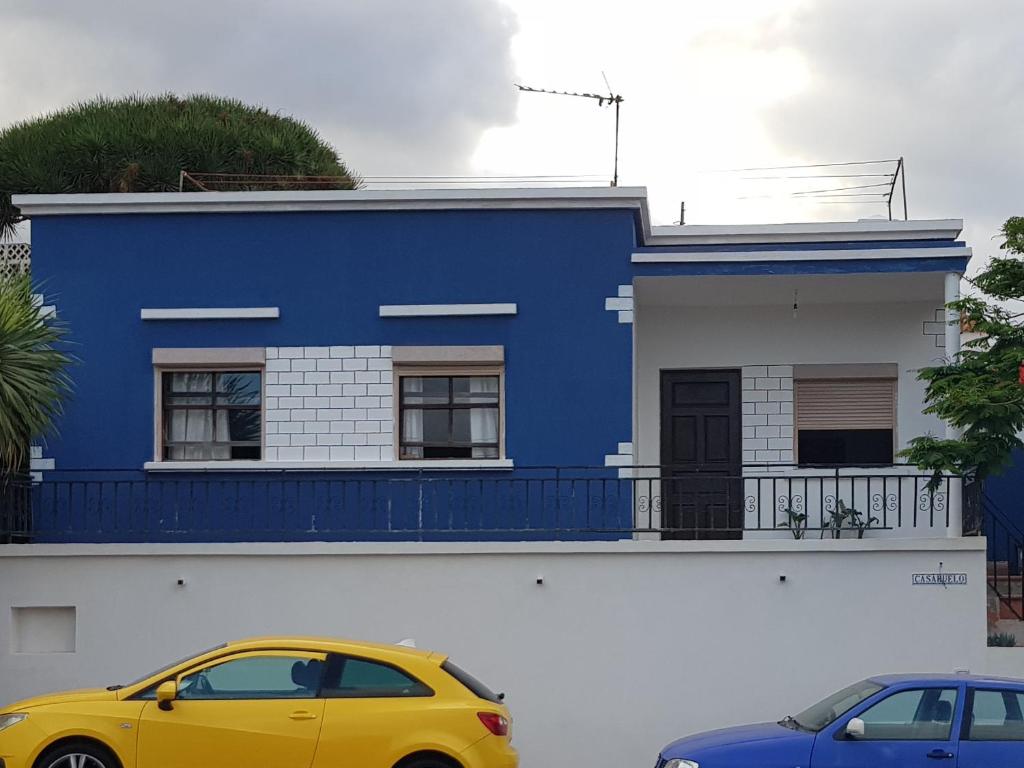 ブレーニャ・バハにあるCasabueloの青い家の前に停められた車2台