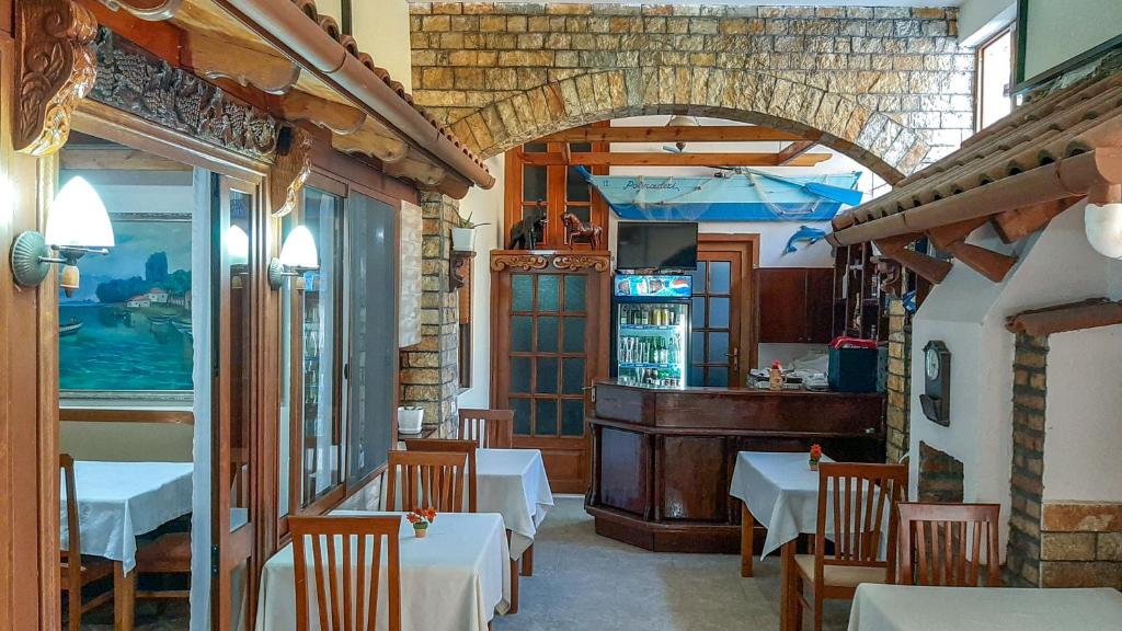 a restaurant with tables and chairs in a room at Vila Korani in Tirana