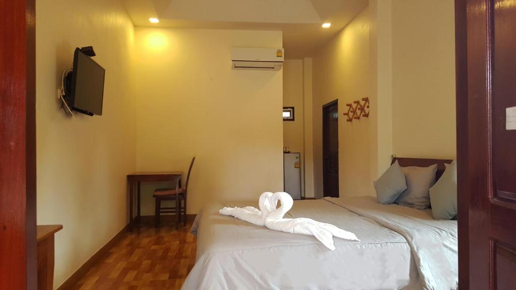 um quarto com uma cama com uma toalha em Sweetville Home em Sangkhla Buri
