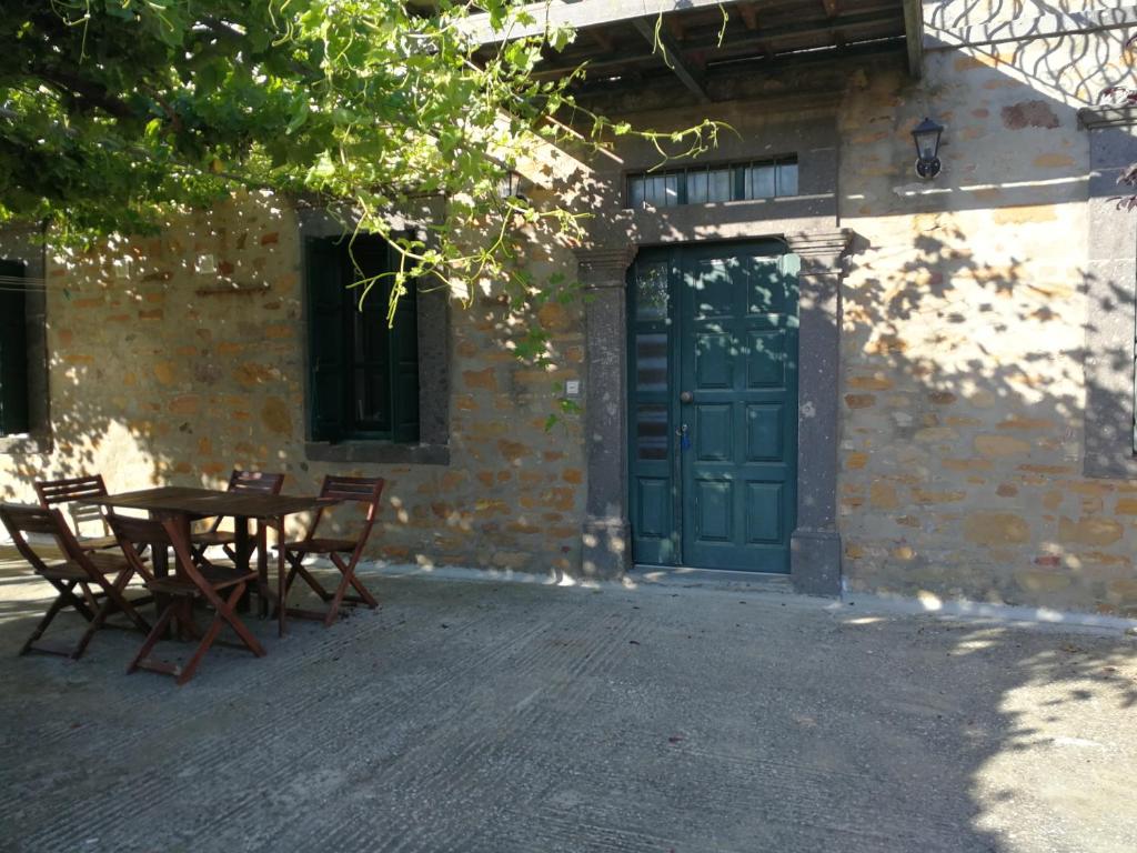 stół i krzesła przed budynkiem z zielonymi drzwiami w obiekcie Terra Lemnia B w mieście Repanídhion
