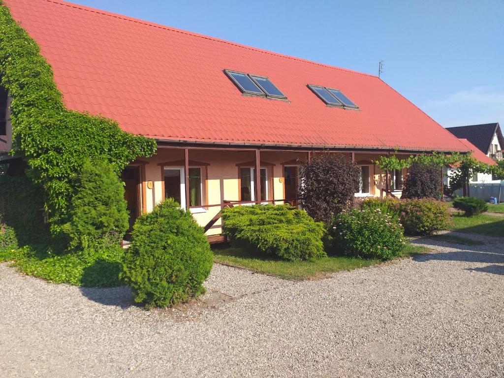dom z czerwonym dachem i krzakami w obiekcie Przestronne domki Sztutowo w Sztutowie