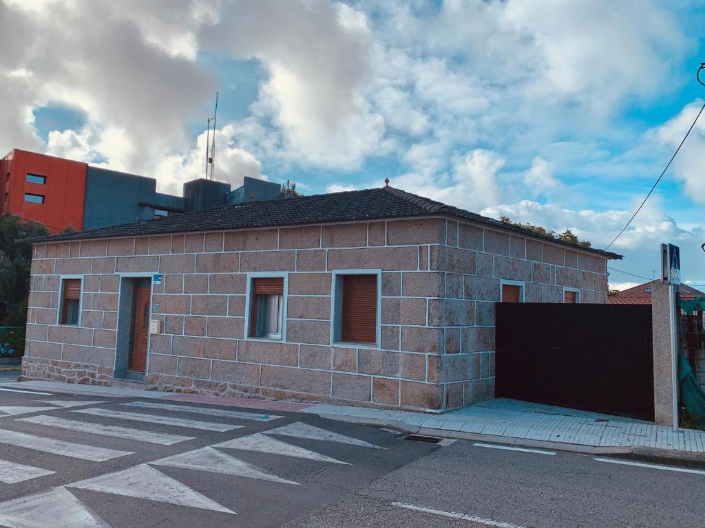 a brick building on the side of a street at Casa A Confianza in Isla de Arosa