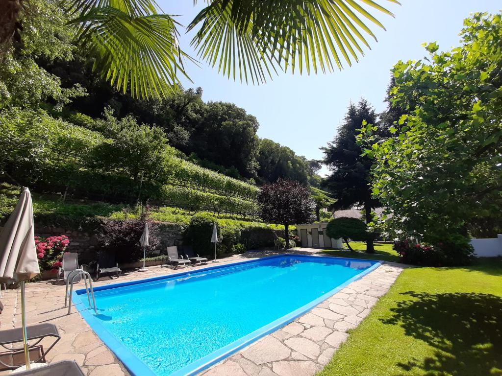 una piscina en un patio con árboles en Agriturismo Sittnerhof, en Merano