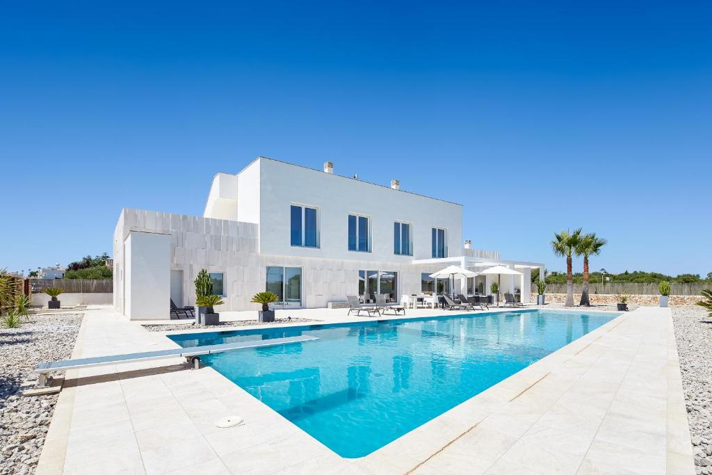 uma villa com piscina em frente a uma casa em Villa Es Trenc em Campos