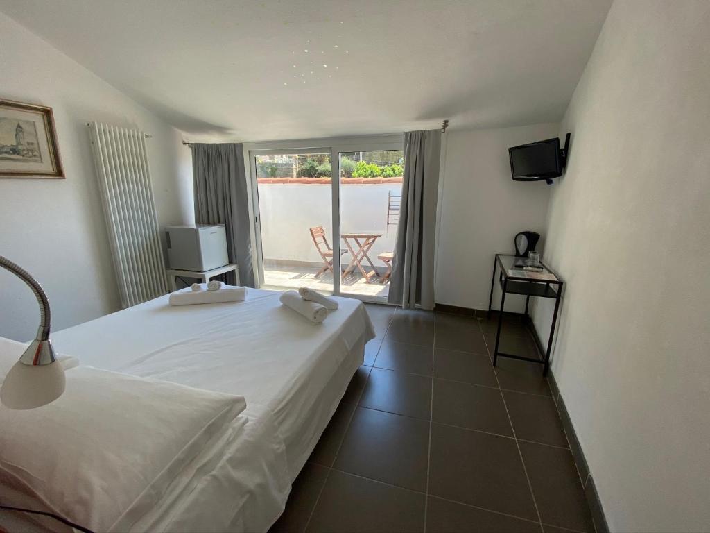 1 dormitorio con cama, TV y balcón en Economy Rooms, en Vernazza