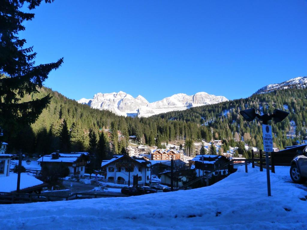 una ciudad cubierta de nieve con montañas en el fondo en Bilocale Alberti - Ragada, en Madonna di Campiglio