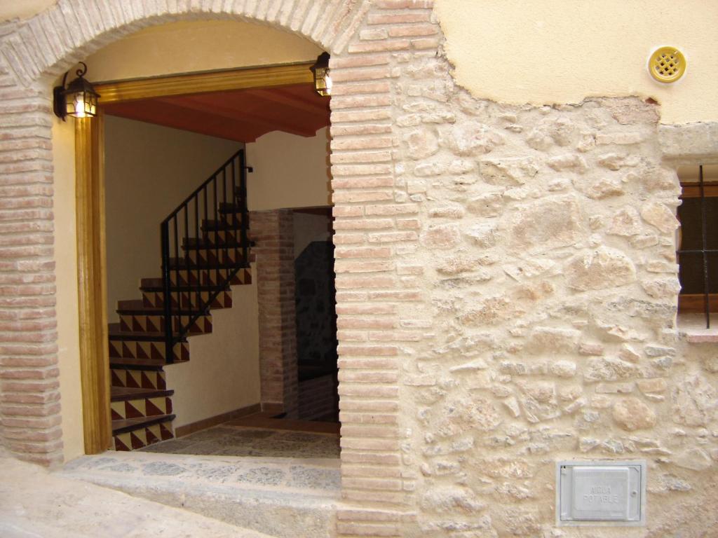 - l'entrée d'une maison avec un mur en pierre et des escaliers dans l'établissement Ca la Monica, à Torre de Fontaubella
