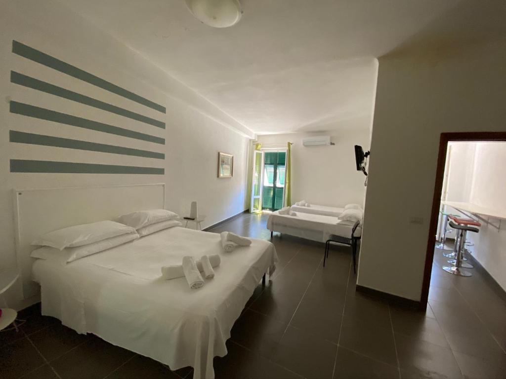 een slaapkamer met een groot wit bed en handdoeken bij Vernazza Holidays Apartments in Vernazza