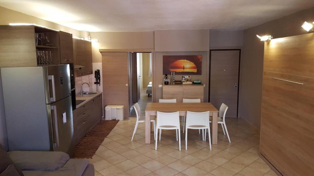 cocina con mesa y sillas blancas en una habitación en Condominio Le Palme, en Santa Teresa Gallura