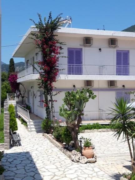 une maison blanche avec des fleurs sur son côté dans l'établissement Nidri Studios Apartments, à Nydri