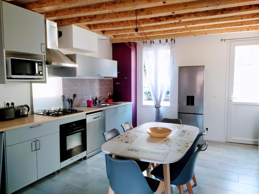 a kitchen with a table and chairs in a room at Casa Louka in Saint-Aignan