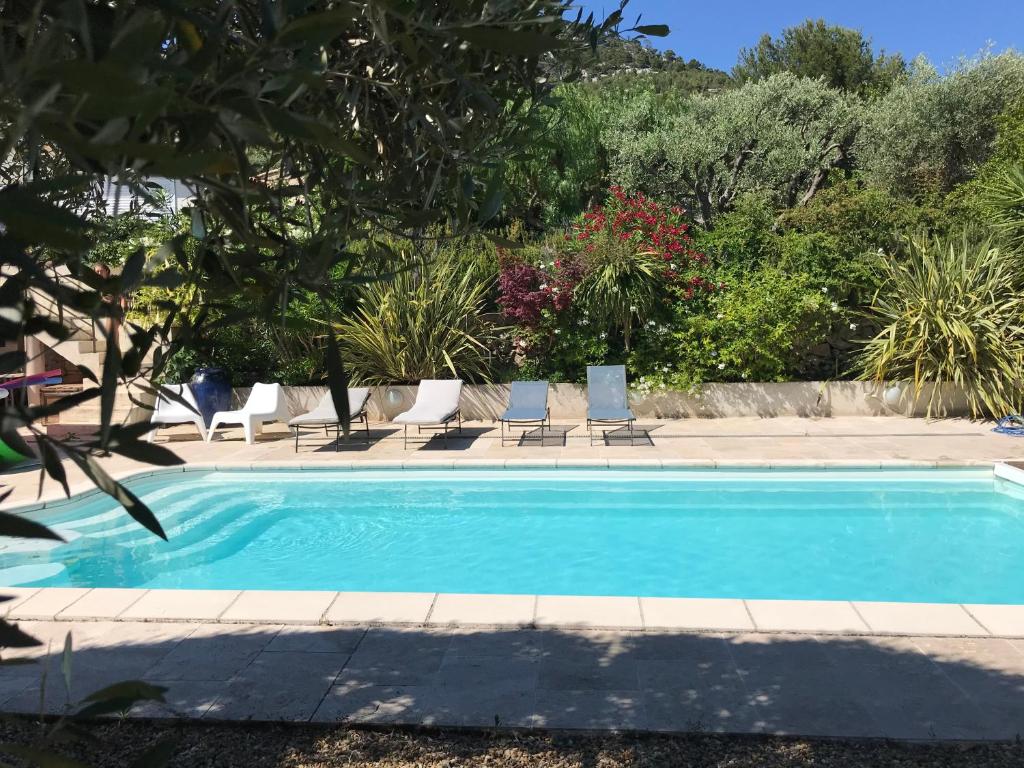 una piscina con sedie a sdraio e alberi di les Chambres d'Amis a Sanary-sur-Mer