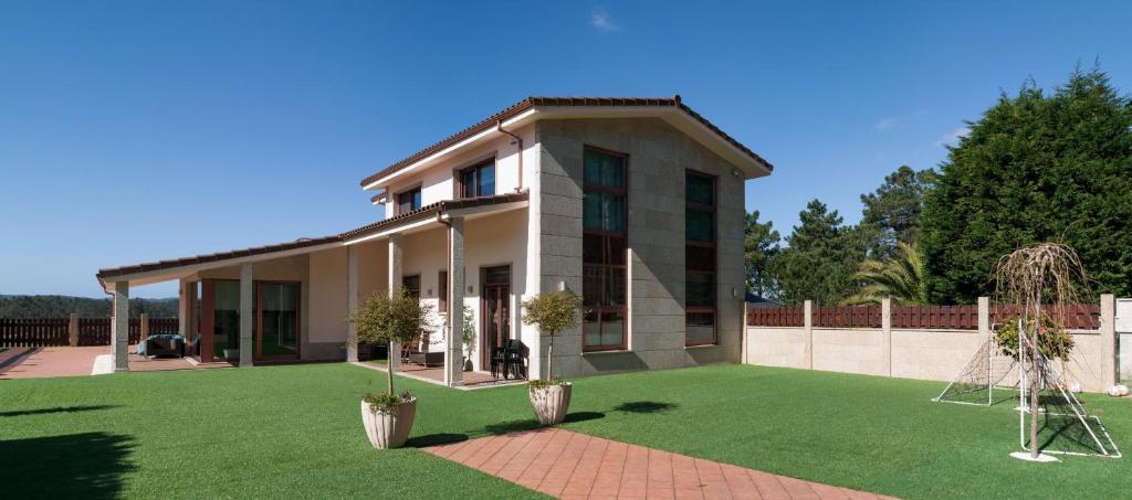 a house with a lawn in front of it at Chalet Vilanova in Cee
